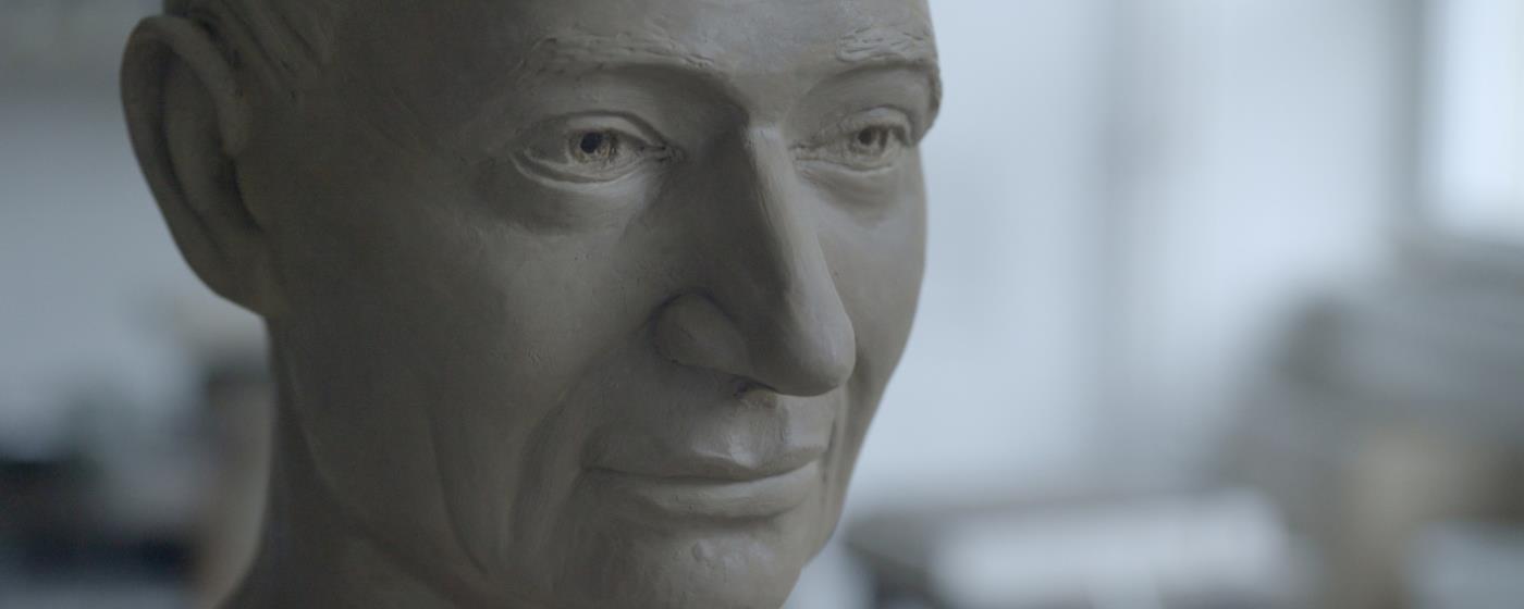 Clay sculpture of a man's head.