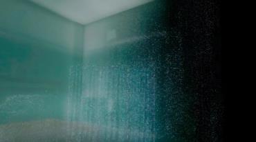 Zrnitý obraz místnosti s nejasnými konturami a modrozeleným nádechem.